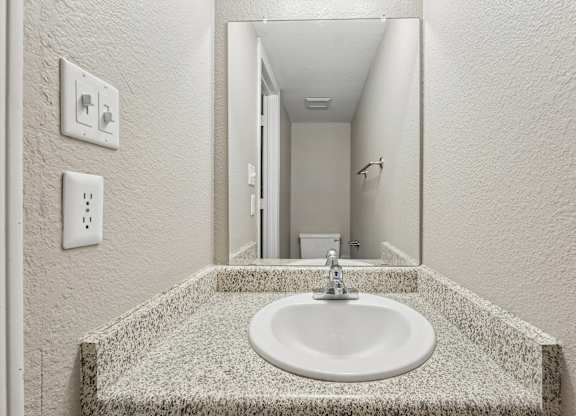 A bathroom with a sink and mirror.