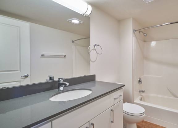 A white bathroom with a sink, toilet, and bathtub.