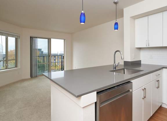 A kitchen with white cabinets and a stainless steel dishwasher.