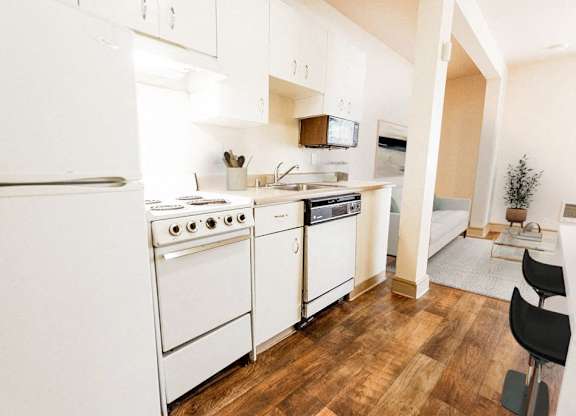 a kitchen with white appliances and a wood floor at Zindorf, Seattle, Washington
