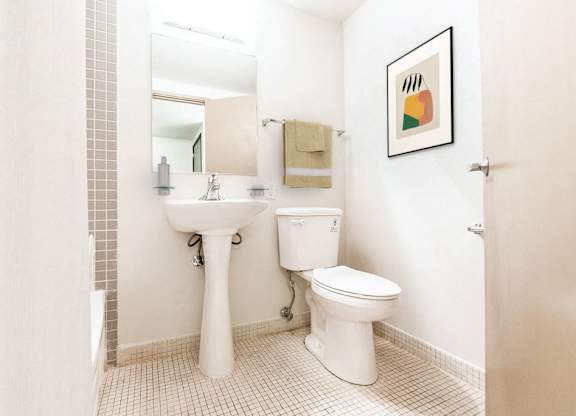 A white toilet and sink in a small bathroom.