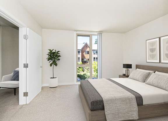 A bedroom with a large bed and a potted plant.