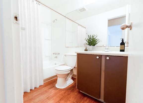 A white toilet sits in a bathroom next to a brown cabinet.