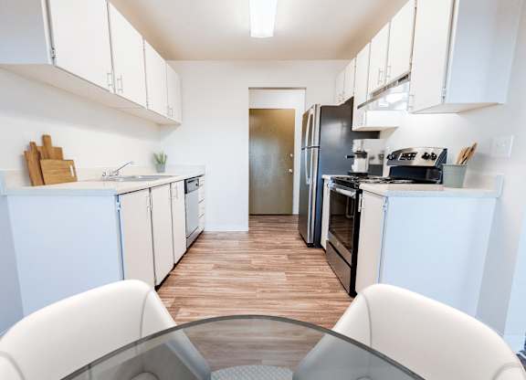 A modern kitchen with white cabinets and a black refrigerator.