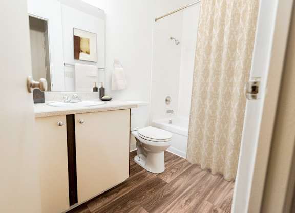 A white bathroom with a toilet, sink, and shower.