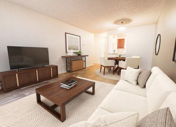 A living room with a white couch and a wooden coffee table.