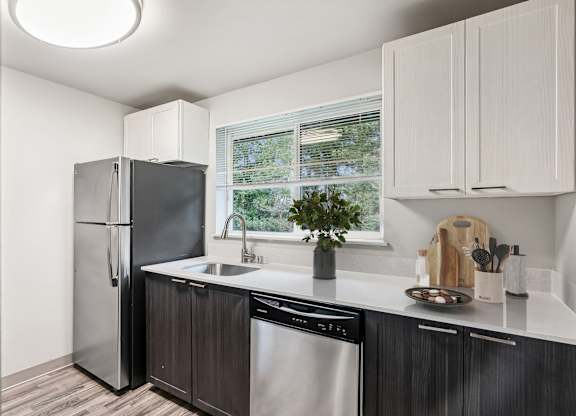 A kitchen with a black fridge and a black dishwasher.