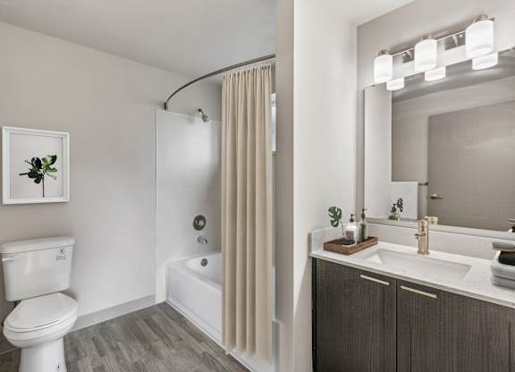 A white toilet sits next to a white bathtub in a bathroom.