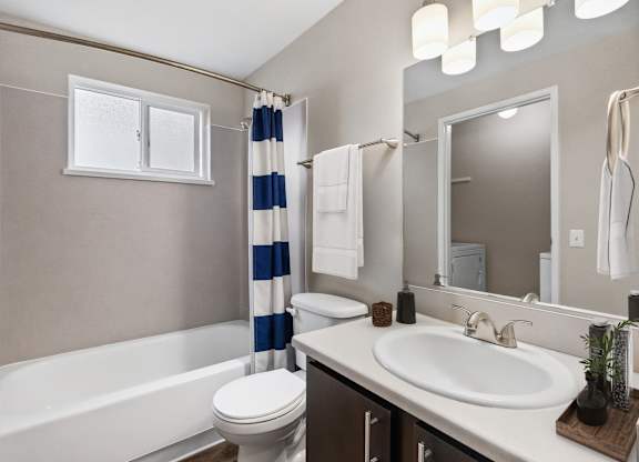 A bathroom with a white tub, toilet, and sink.