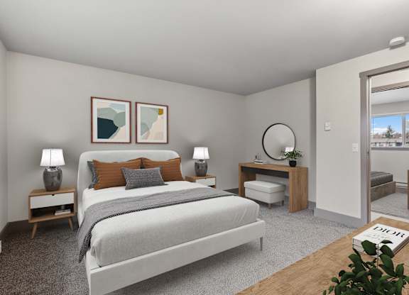 A bedroom with a large bed, two lamps, and a plant.