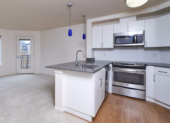 A kitchen with white cabinets and a large island.