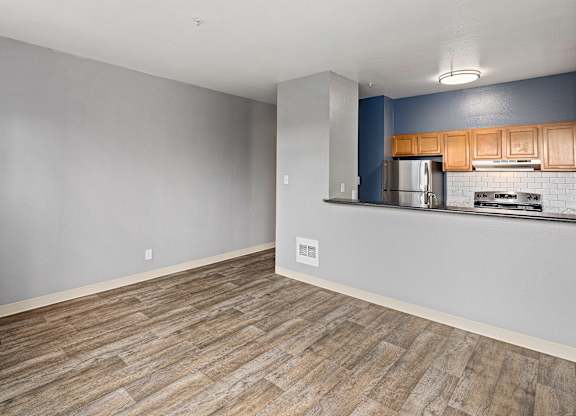 A kitchen with wooden cabinets and a stainless steel refrigerator.