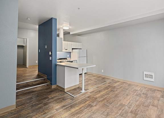 A kitchen with a blue wall and white countertops.