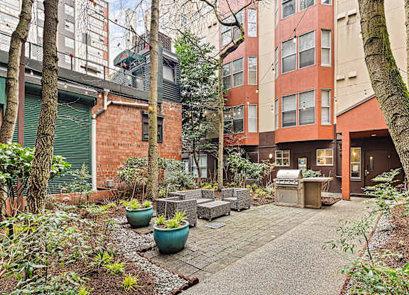A courtyard with a bench and potted plants.