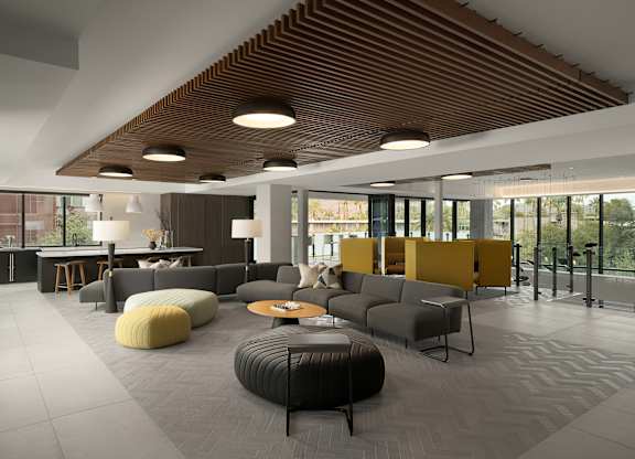 A modern living room with a wooden ceiling and grey sofas.