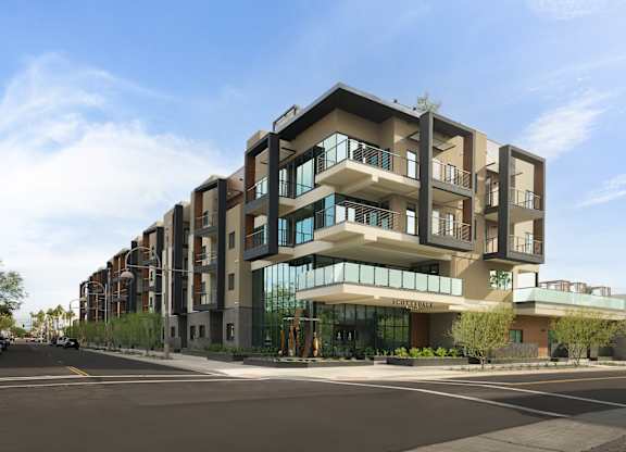A modern apartment building with a clear blue sky above.