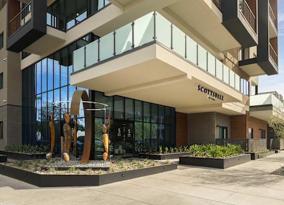 A modern building with a sculpture in front of it.
