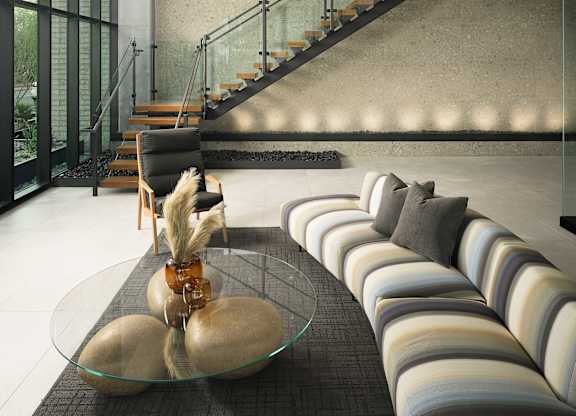 A modern interior with a glass table and striped sofas.