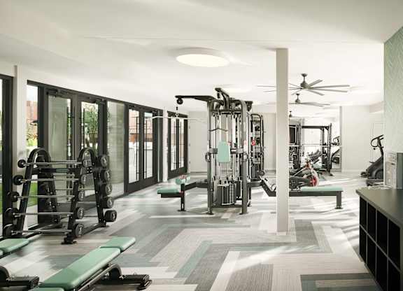 A gym with a variety of equipment including weights and cardio machines.