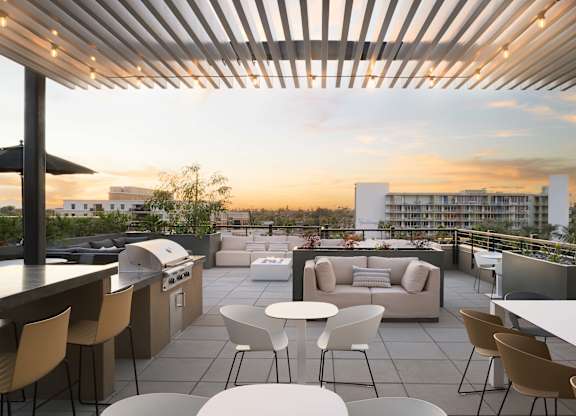 A rooftop patio with a bar and seating area.