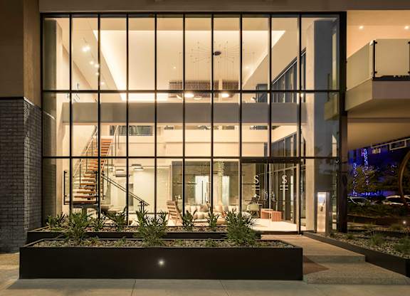 A modern house with a glass entrance and a staircase.