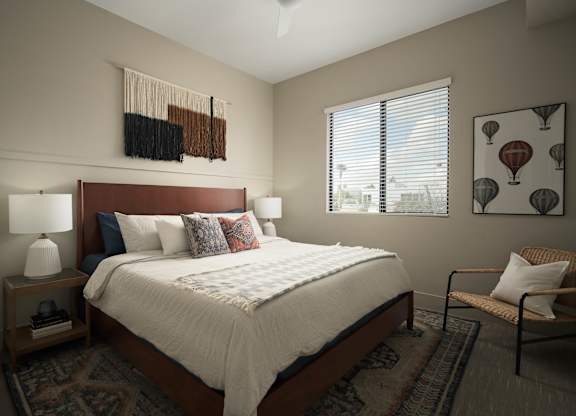 A bedroom with a bed, a chair, and a window.