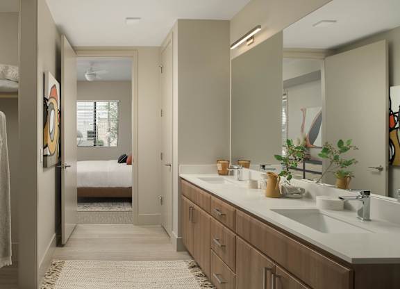 A bathroom with a white counter top and a mirror above it.