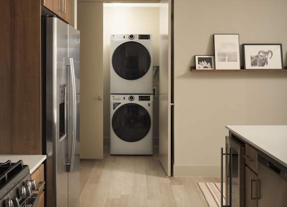 A modern kitchen with a washer and dryer built into the wall.