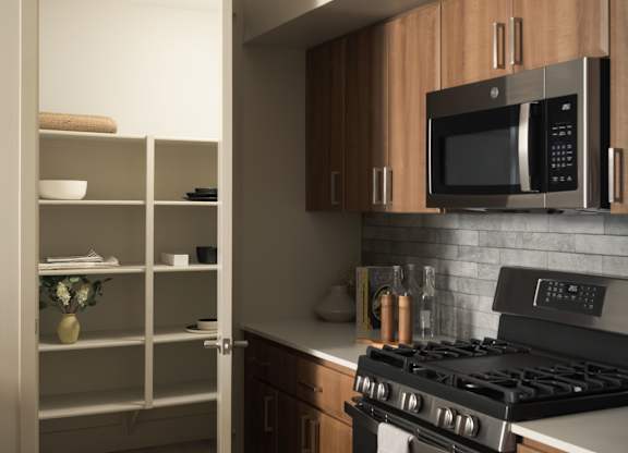 A modern kitchen with a black stove and wooden cabinets.