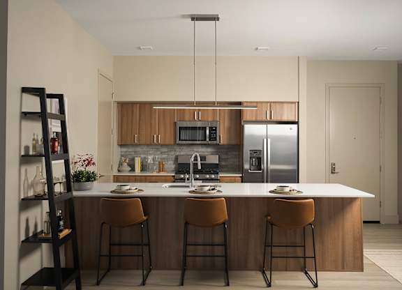 A kitchen with a white countertop and wooden cabinets.