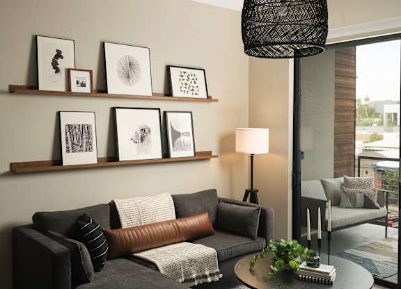 A living room with a grey couch, a coffee table, and a lamp.