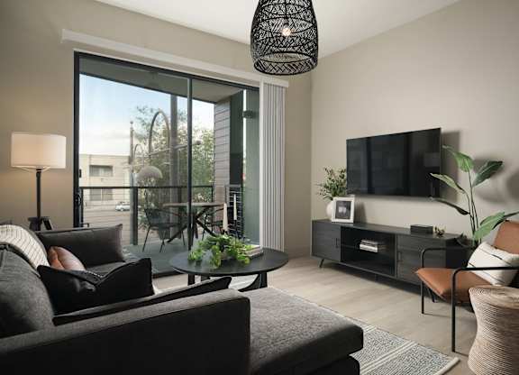A living room with a grey couch and a black lamp.
