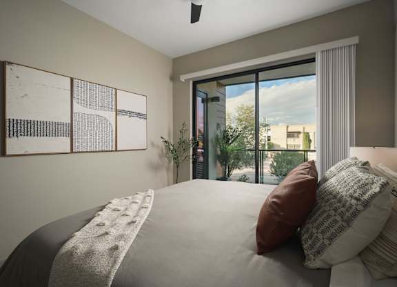 A bedroom with a large bed and a view of the city through the window.