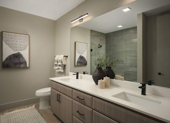 A bathroom with a toilet, sink, and mirror.