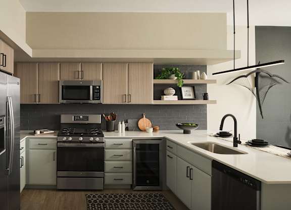 A modern kitchen with a refrigerator, stove, and sink.