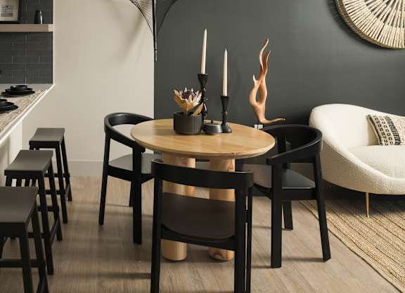 A modern dining room with a round table and chairs.