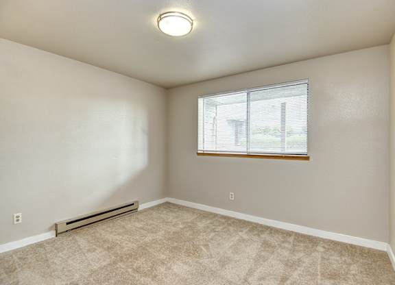 Seattle Apartments-  a bedroom with carpet and a window.