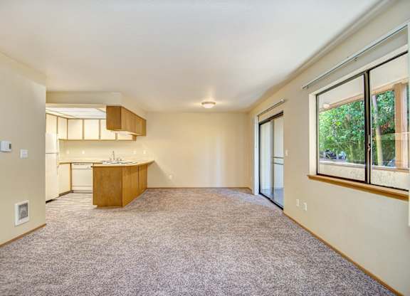 A large, empty room with a kitchen area in the background. at Autumn Village, Milton