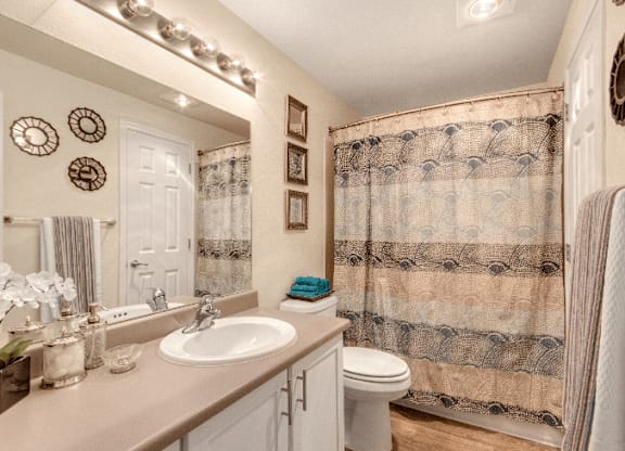 A bathroom with a floral shower curtain and a white sink. at The Retreat, Sumner, Washington