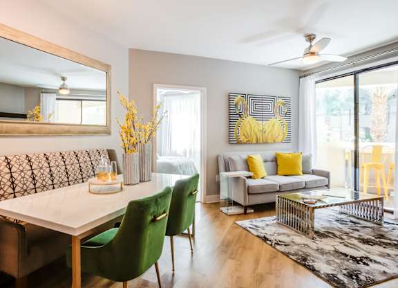 A dining room with a white table and green chairs.
