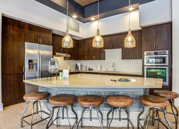 A kitchen with a bar stool in front of the island.