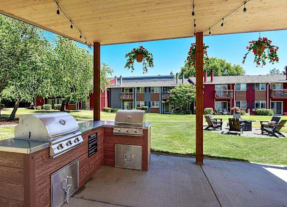 A barbecue grill is set up under a wooden canopy. at Brookstone, Washington, 98198