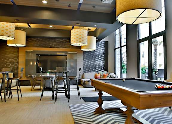 A room with a pool table and a bar area.