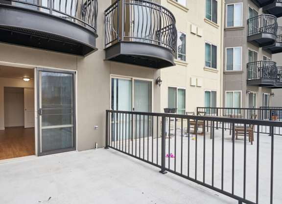 A balcony with black railings and a white floor.