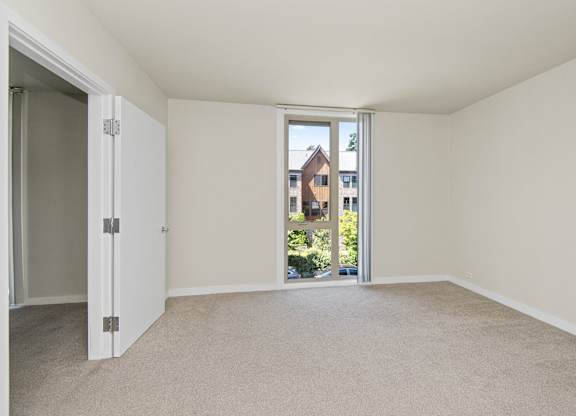 a bedroom with an open door and a carpeted floor at Cosmopolitan, Washington