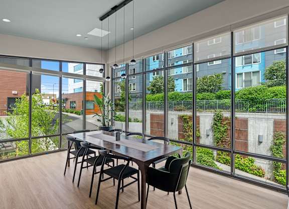 a dining room with floor to ceiling windows and a table and chairs at Baldwyn, Seattle, WA 98125