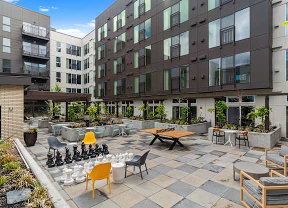 an outdoor patio with tables and chairs at an apartment building at Baldwyn, Washington, 98125