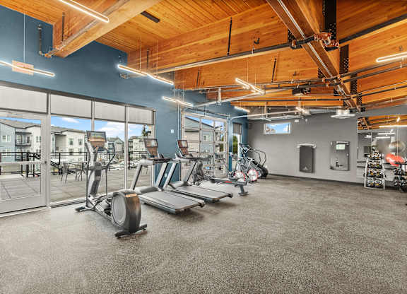 A gym with a variety of equipment including treadmills, weights, and exercise machines.