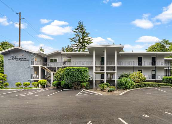 A large white building with a parking lot in front.