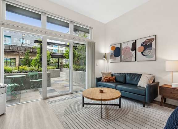 a living room with a couch and a coffee table and sliding glass doors